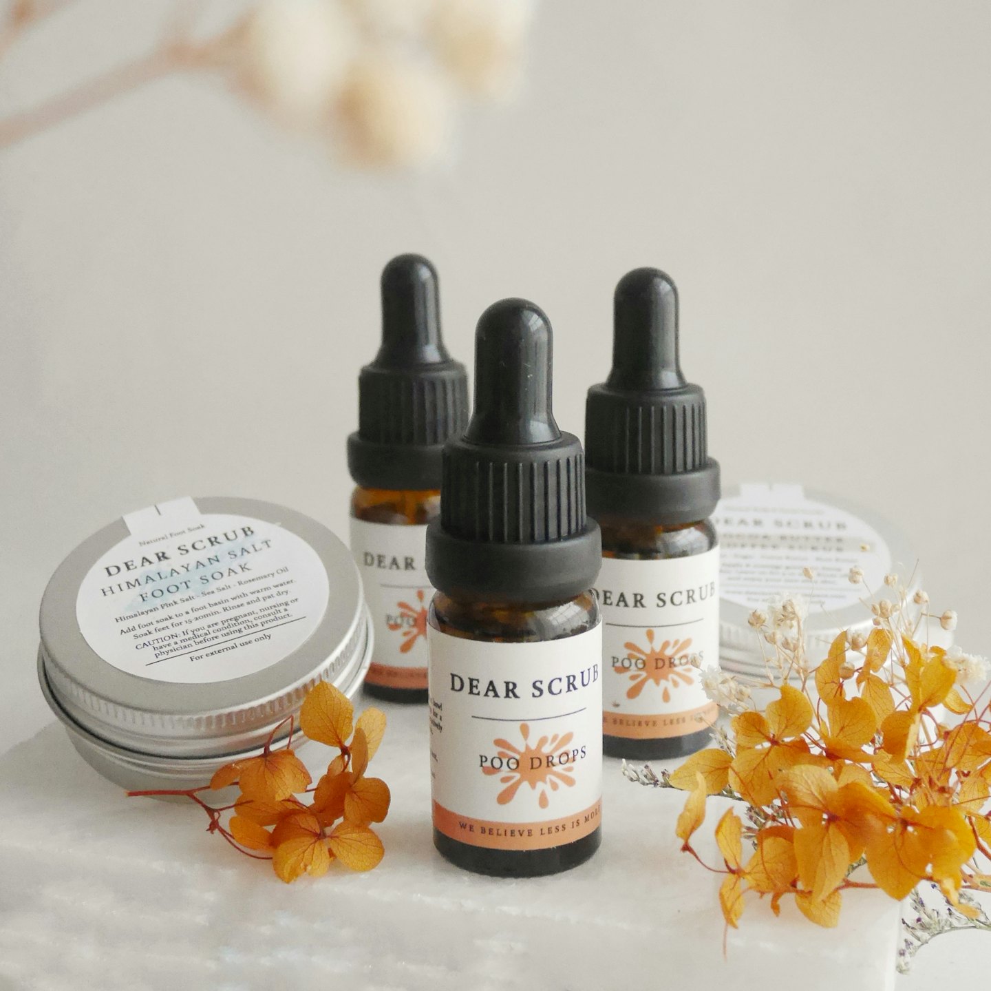 Natürliche Hautpflegeprodukte mit Orangenblüten auf Marmor.